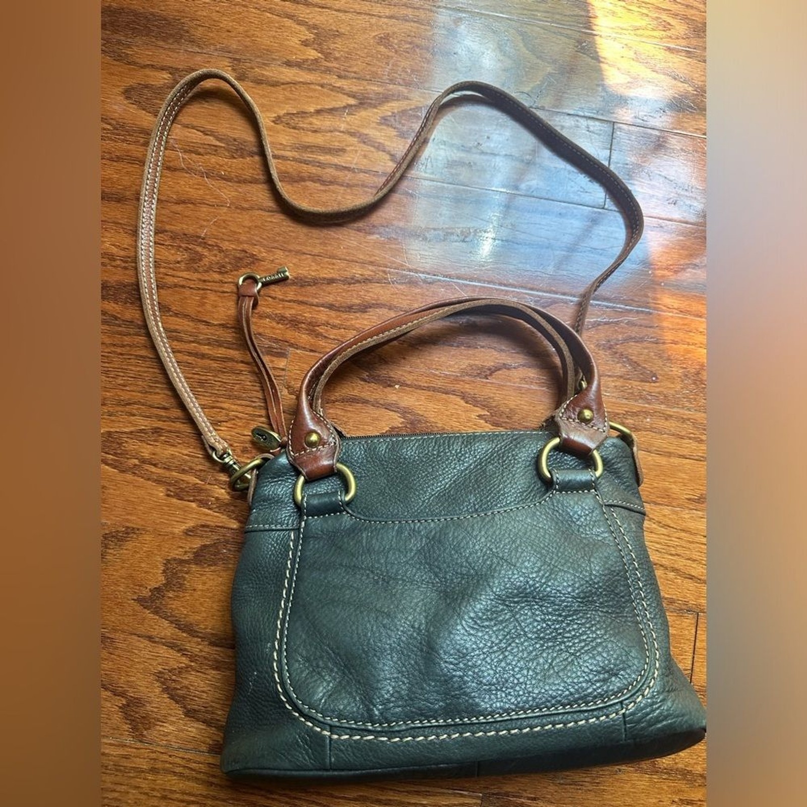 Fossil purse is black pebbled leather & brown leather straps & brass hardware