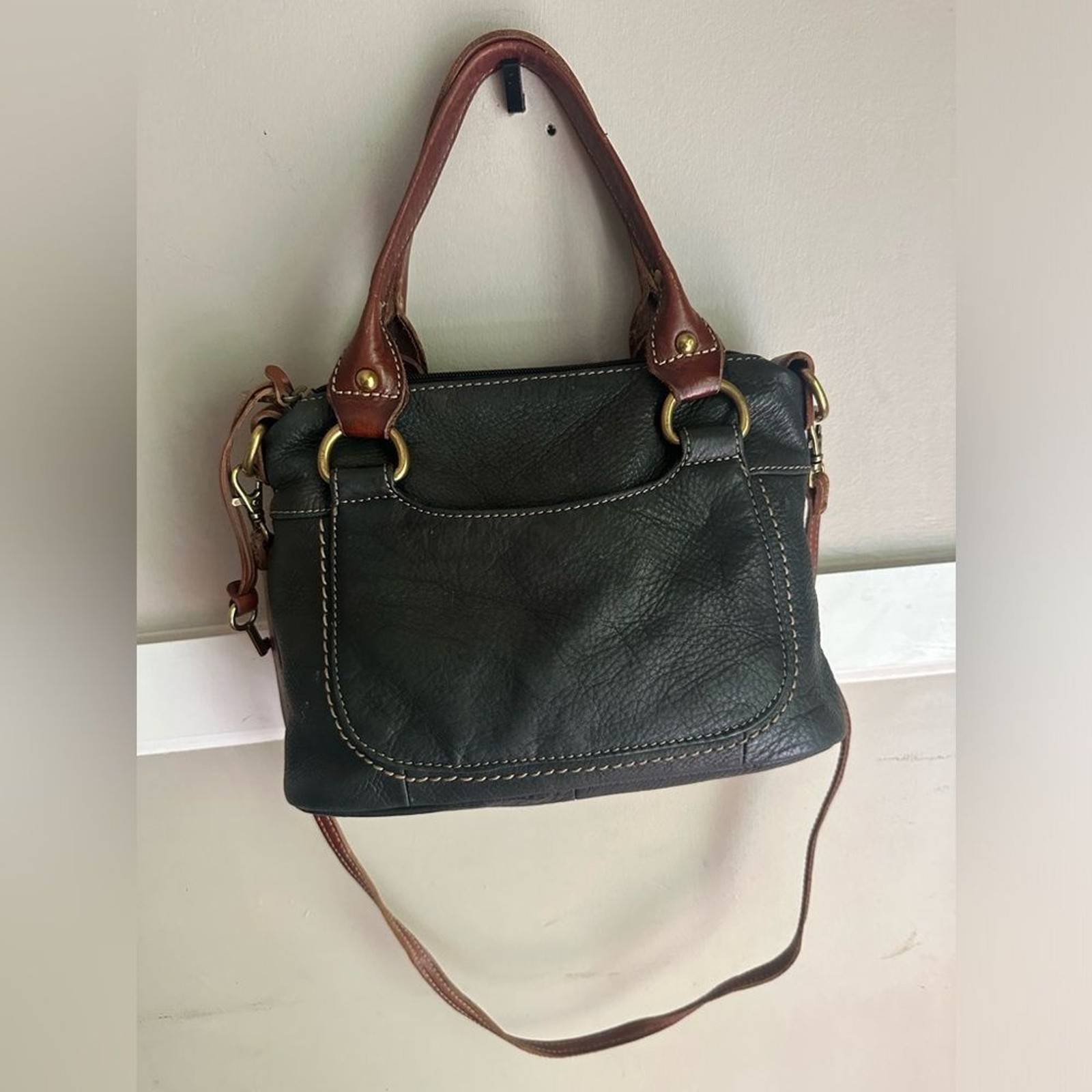 Fossil purse is black pebbled leather & brown leather straps & brass hardware