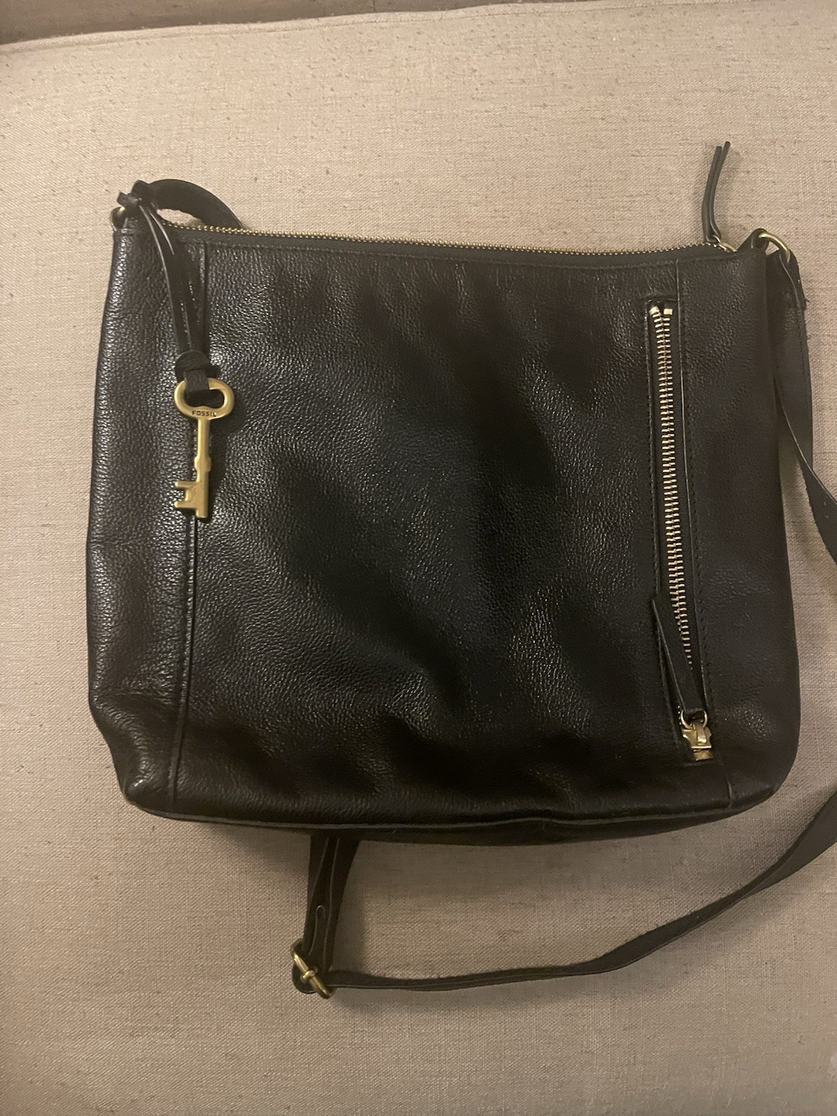 Black Fossil Tara leather crossbody bag featuring a distinctive gold-toned key