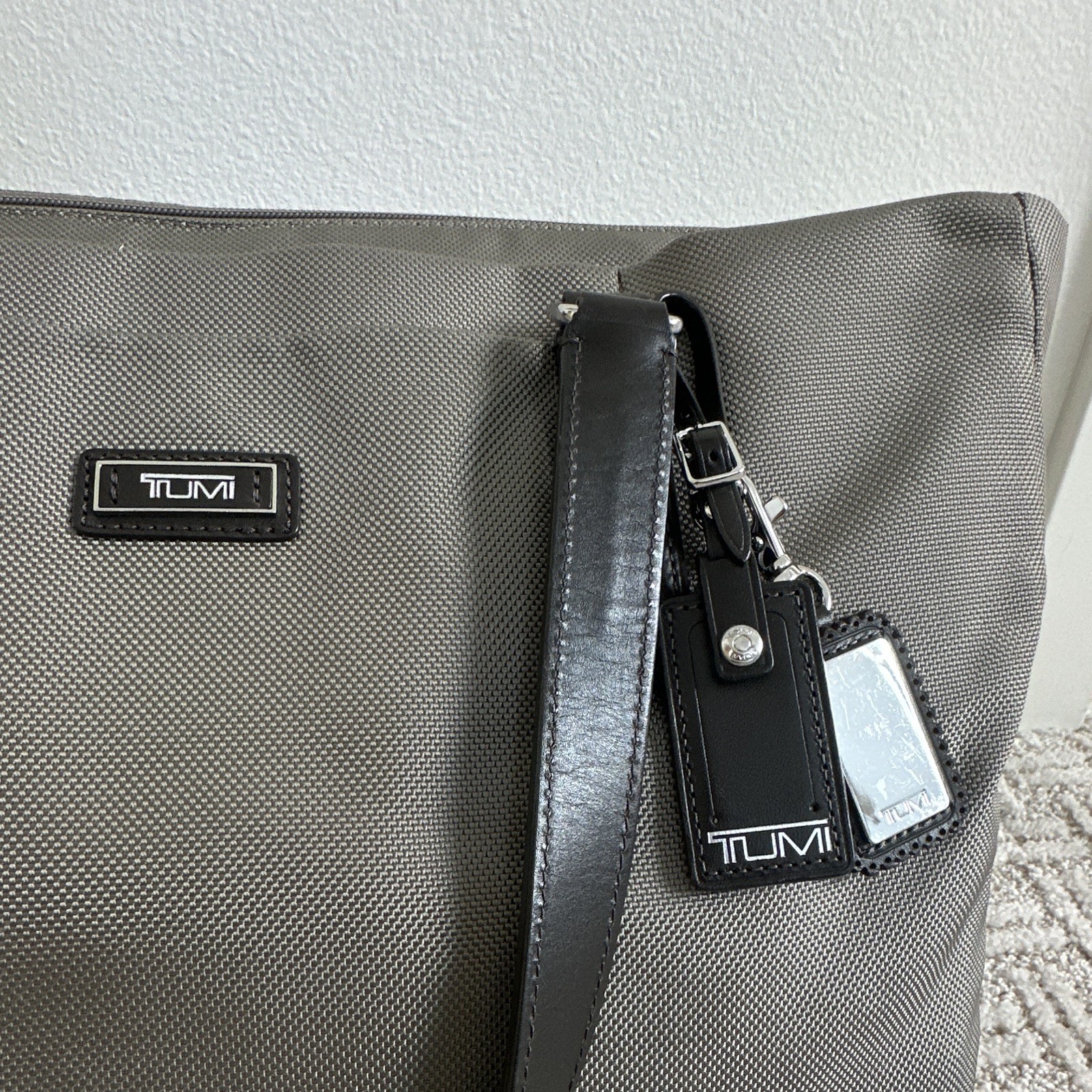 TUMI Beige Tote Bag Zip Top Black Leather Shoulder Straps Luggage Tag Pockets