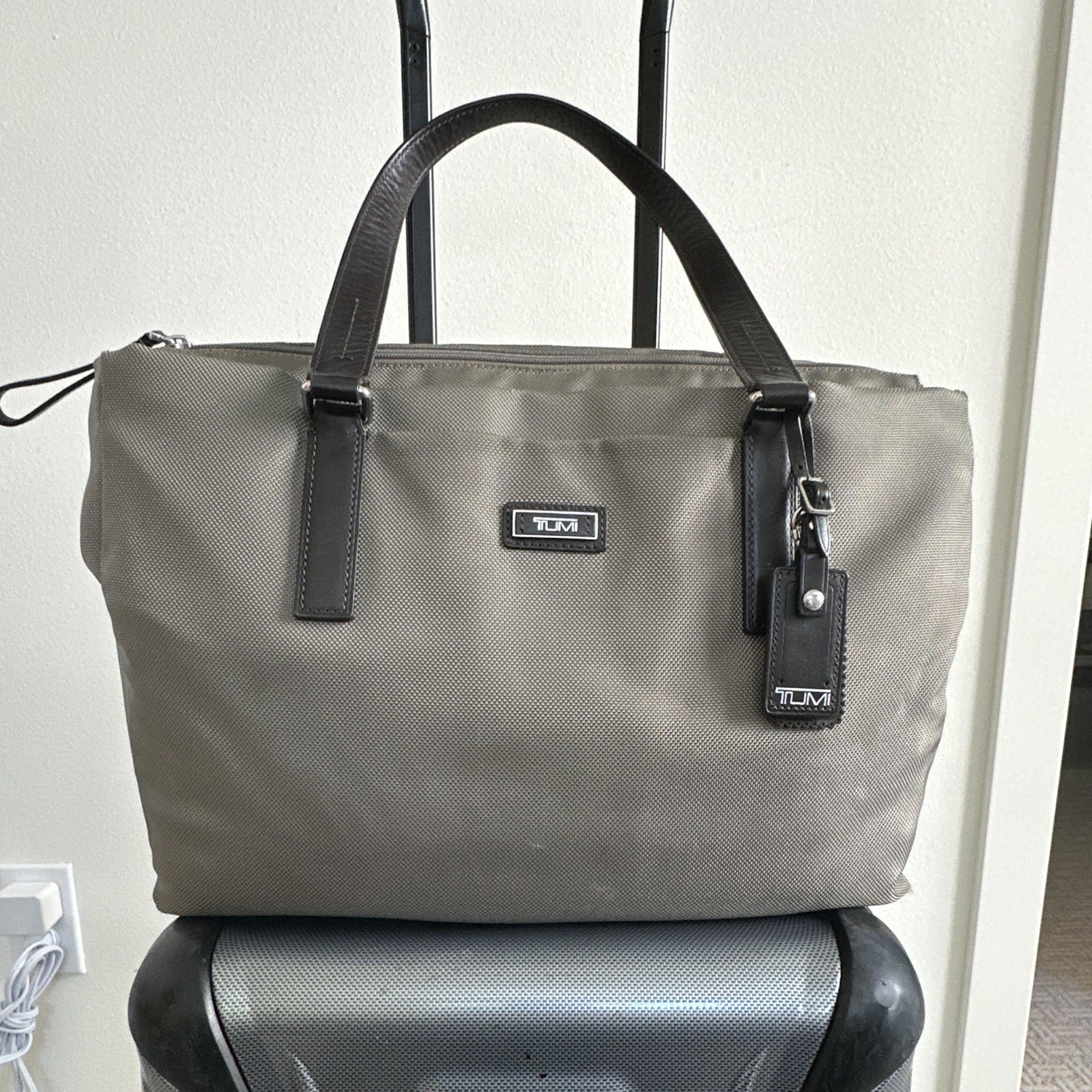 TUMI Beige Tote Bag Zip Top Black Leather Shoulder Straps Luggage Tag Pockets